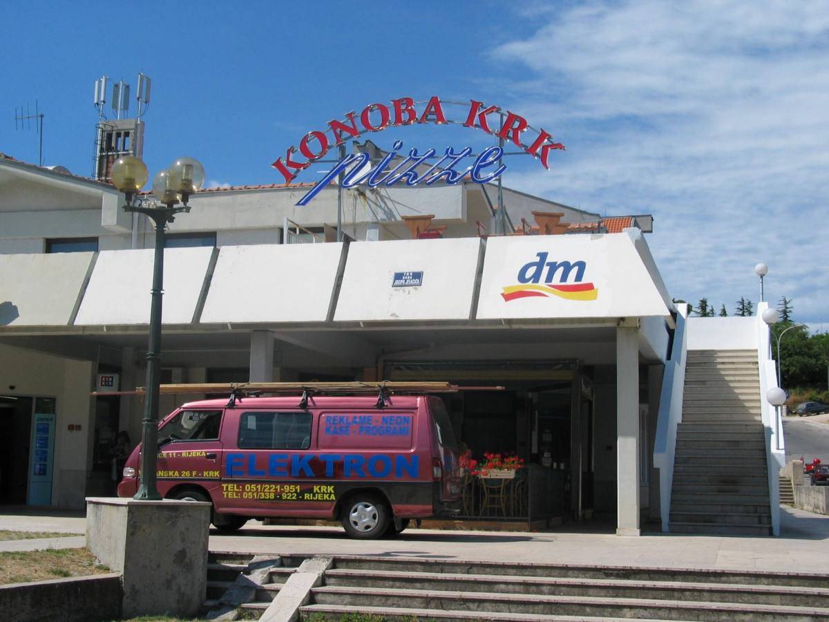 Natpis Konoba Krk nad poslovnim prostorom, s Elektronovim vozilom ispred